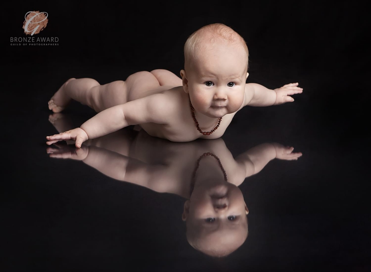 Bronze award for reflection shot of baby lying on his tummy in the aeroplane position